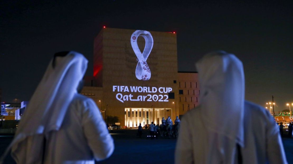 Qataríes se reúnen en el tradicional mercado Souq Waqif de Doha mientras se proyecta el logo oficial del Mundial 2022 en un edificio en septiembre de 2019.