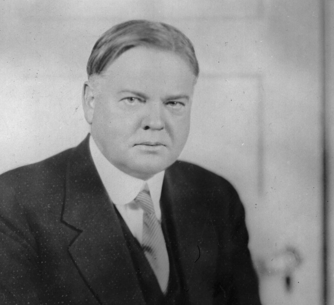 Herbert Hoover (1874 - 1964), más tarde el 31º presidente de los Estados Unidos, sentado en un escritorio escribiendo.