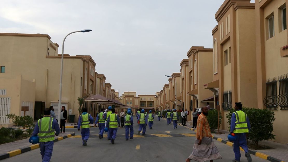 Obreros extranjeros que trabajan en las obras de construcción del estadio de fútbol Al-Wakrah, uno de los estadios de la Copa del Mundo de 2022 de Qatar, caminan de vuelta a su alojamiento en el complejo Ezdan 40 después de terminar el trabajo el 4 de mayo de 2015, en los suburbios del sur de Al-Wakrah en Doha. Crédito: Marwan Naamani/AFP/Getty Images/FILE