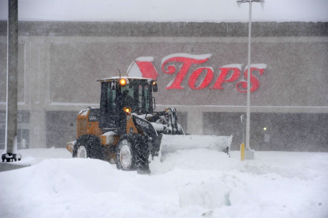 Una excavadora levanta nieve en un estacionamiento tras una intensa nevada en Hamburg, Nueva York.