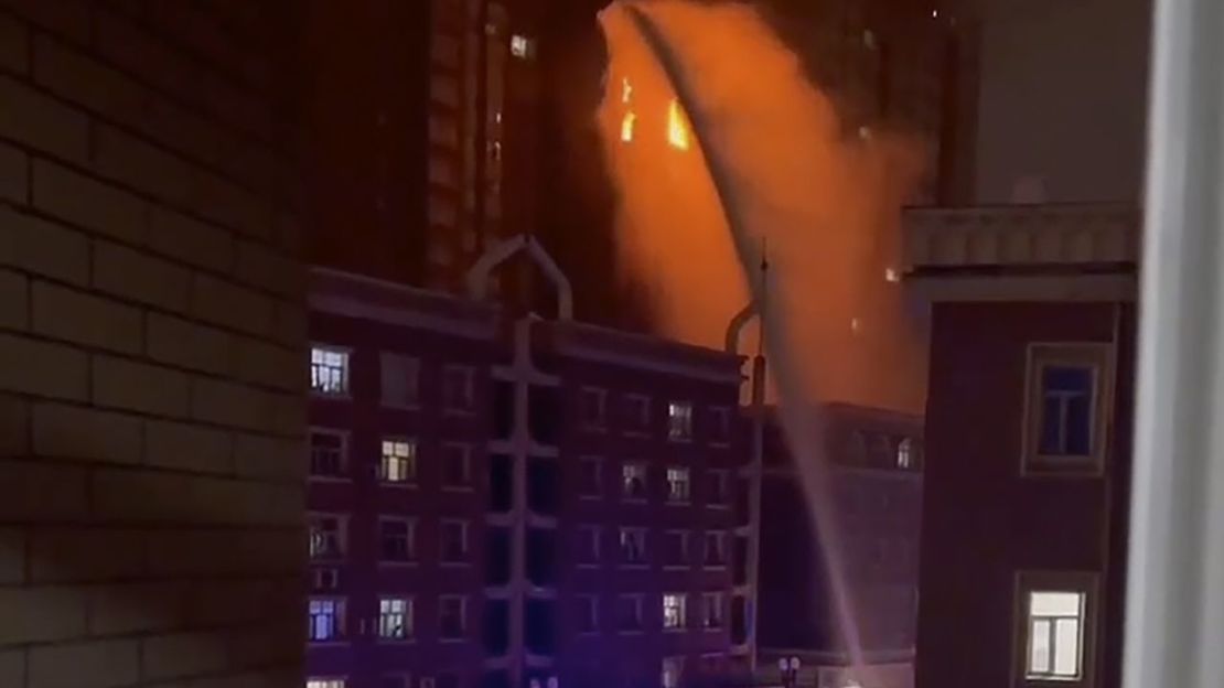 Los bomberos rocían agua sobre un incendio en un edificio residencial en Urumqi, en la región occidental china de Xinjiang, el 24 de noviembre de 2022.