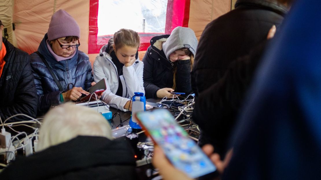 Los habitantes de Jersón cargan sus teléfonos en una tienda de campaña proporcionada por la administración local.