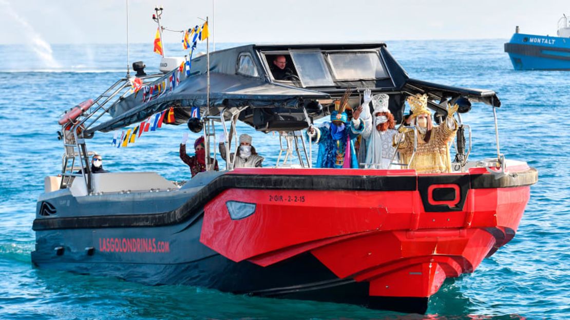 Artistas vestidos como los Reyes Magos - Melchor, Caspar y Baltasar - llegan a bordo de un barco a la playa de Bogatell en Barcelona el 5 de enero de 2021, durante las celebraciones de la Epifanía. Crédito: Pau Barrena/AFP/Getty Images