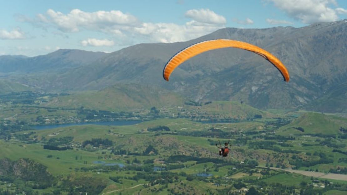 Un parapente surca los cielos de Nueva Zelandia, donde las actividades al aire libre y la Navidad van de la mano. Crédito: damianalmua/Adobe Stock