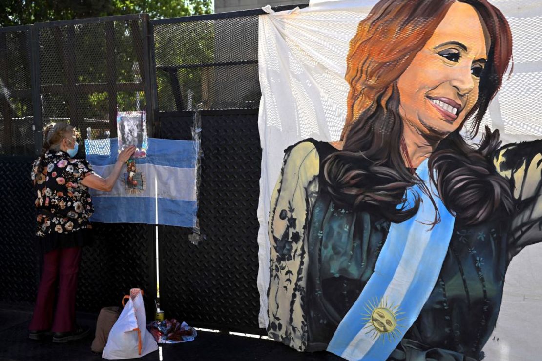 Una simpatizante de la vicepresidenta Cristina Fernández de Kirchner pega un cartel frente a los tribunales de Comodoro Py, en Buenos Aires, el 6 de diciembre de 2022.