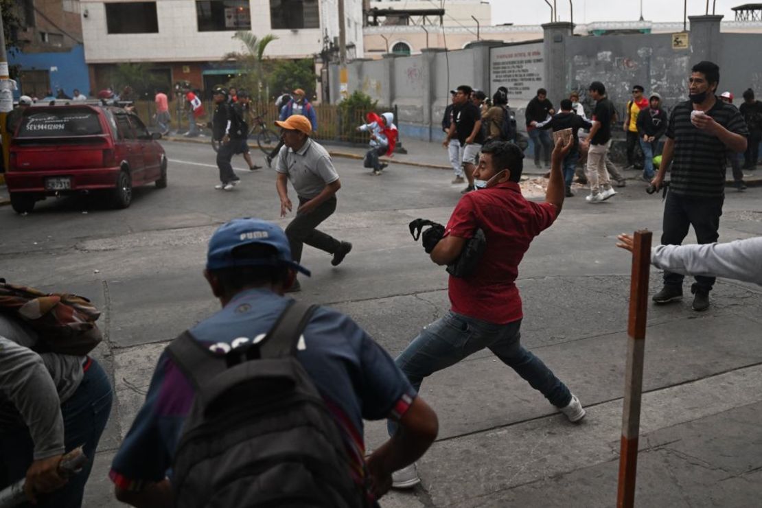 Partidarios del expresidente peruano Pedro Castillo chocan con la policía para llegar a la Prefectura de Lima, donde Castillo está detenido, en Lima, el 7 de diciembre de 2022.