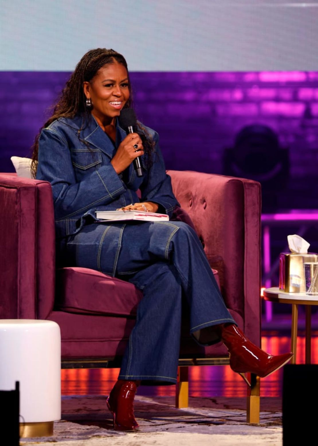 La ex primera dama Michelle Obama habla en el escenario durante la gira del libro "The Light We Carry" con un conjunto de mezclilla de Ganni. Crédito: Tasos Katopodis/Getty Images North America/Getty Images for Live Nation