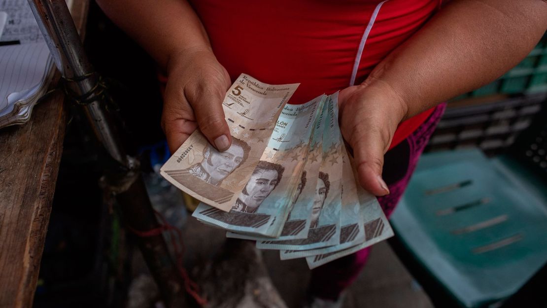 Una mujer cuenta billetes de bolívar en un mercado callejero en la comunidad José Félix Ribas en el barrio de Petare en Caracas el 5 de noviembre de 2022. Crédito: FEDERICO PARRA/AFP vía Getty Images