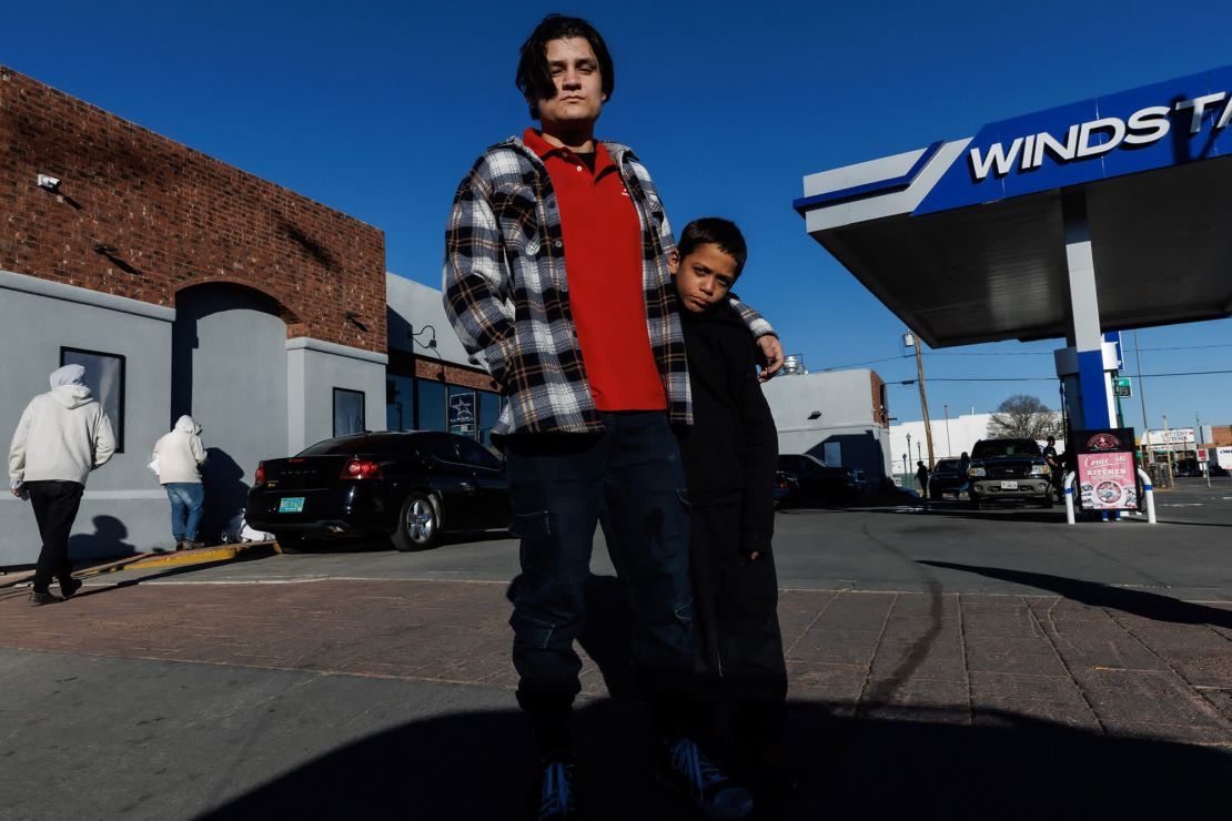 Daniel Banda, a la izquierda, interactúa con decenas de migrantes a diario mientras trabaja en una tienda de conveniencia y gasolinera en el centro de El Paso. Está de pie con un niño migrante de Nicaragua.