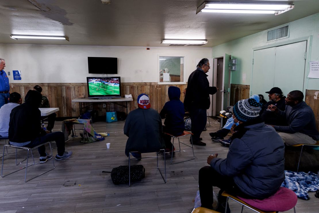 En un refugio administrado por el Centro de Oportunidades para Migrantes Sin Hogar, los migrantes y las personas sin hogar vieron el partido de fútbol de la Copa Mundial entre Francia y Marruecos.