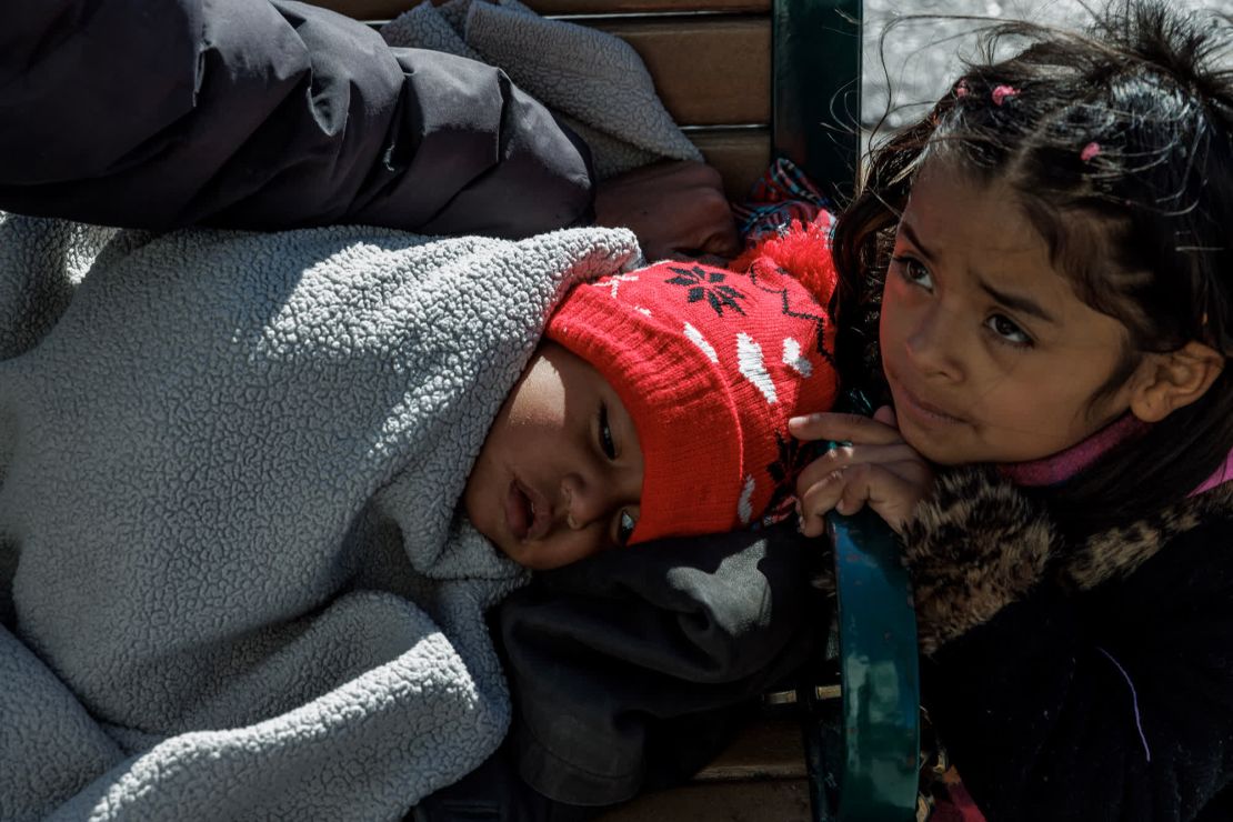 Andrés Alejandro Palacios, a la izquierda, un niño de 2 años de Honduras y su hermana de 6 años, Anna Marbella Jackson, a la derecha, descansan en un banco en el centro de El Paso. Su abuela le dijo a CNN que dos extraños los invitaron a su casa para proteger a los niños de las bajas temperaturas.