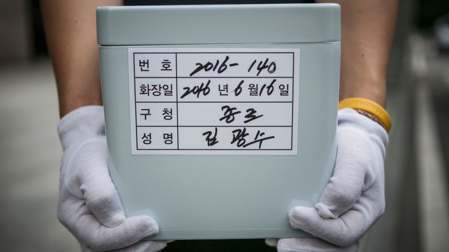 Un trabajador de la organización Good Nanum sostiene una urna con los restos de un hombre que falleció de "muerte solitaria", en 2016 en Goyang, Corea del Sur. Crédito: Jean Chung/Getty Images