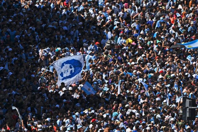 Una bandera con la cara de Diego Armando Maradona entre la multitud que espera a la selección argentina en el obelisco.