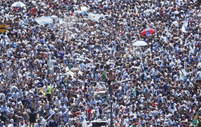 Un aficionado se sienta encima de un poste de luz mientras miles de personas se reúnen durante un desfile de la victoria de la selección nacional masculina de fútbol de Argentina después de ganar la Copa Mundial de la FIFA Qatar 2022 el 20 de diciembre de 2022 en Buenos Aires, Argentina.