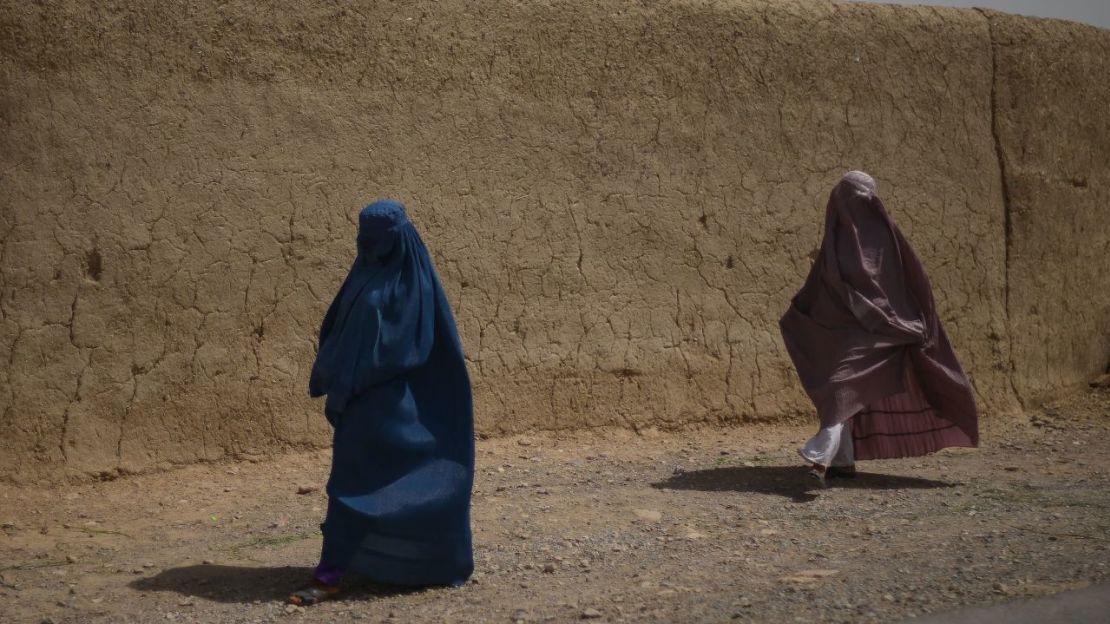 Mujeres afganas caminan junto a un camino en Kandahar el 29 de julio de 2022.