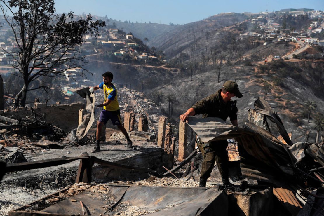 Hombres retiran escombros de casas destruidas por un incendio forestal en los cerros de Viña del Mar, en la región de Valparaíso, Chile, el 23 de diciembre de 2022.