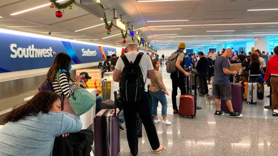 Los viajeros esperan en un mostrador de equipaje de Southwest Airlines para recuperar sus maletas después de vuelos cancelados en el Aeropuerto Internacional de Los Ángeles, el lunes 26 de diciembre de 2022, en Los Ángeles.