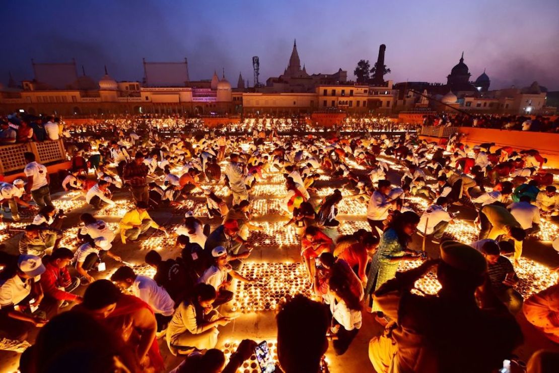 La gente enciende lámparas de barro a orillas del río Sarayu durante las celebraciones de Deepotsav en la víspera del festival hindú de Diwali en Ayodhya el 3 de noviembre de 2021.