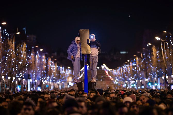 La gente ve un spectáculo de luz y sonido proyectado en el Arco del Triunfo en París. Aurelien Morissard/AP