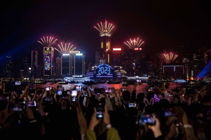 Personas ven un espectáculo de fuegos artificiales y láser en Hong Kong. Isaac Lawrence/AFP/Getty Images