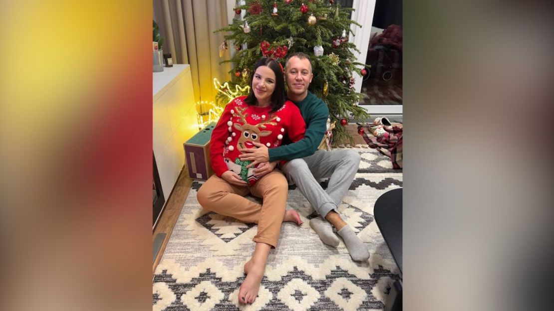 Kateryna y Oleg sentados junto al árbol de Navidad, en su casa, en los suburbios de Kyiv.