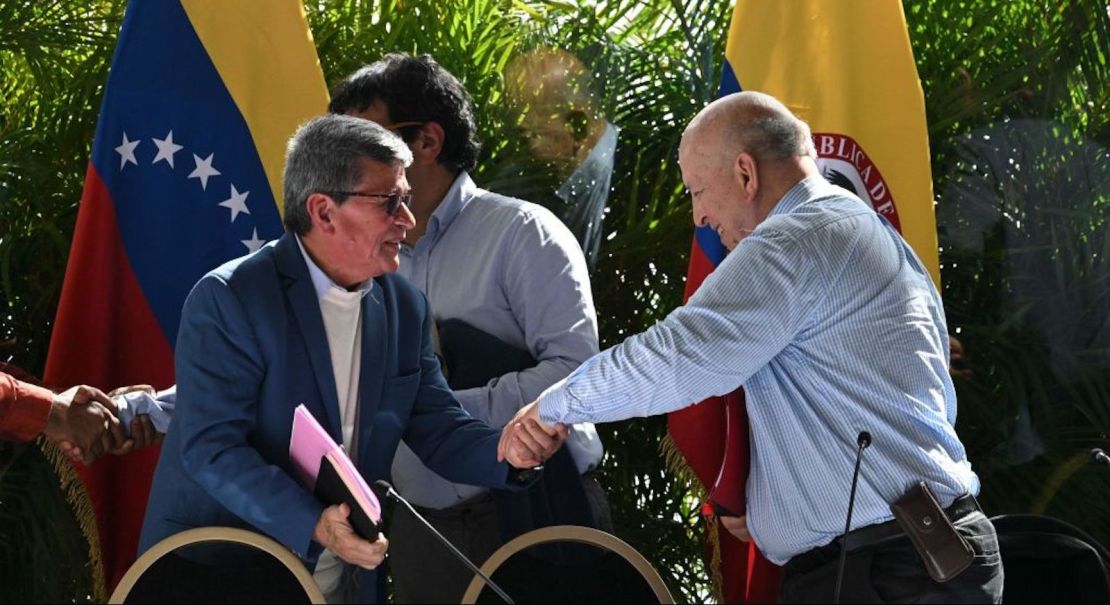 El comandante guerrillero del Ejército de Liberación Nacional (ELN) de Colombia, Pablo Beltrán (L), le da la mano a Otty Patino, miembro de la delegación del gobierno colombiano, durante el cierre de las conversaciones de paz en Caracas el 12 de diciembre de 2022.