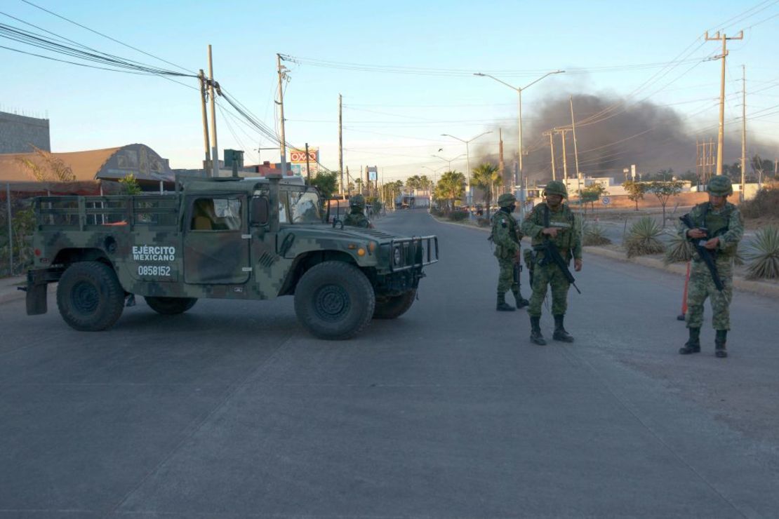 Soldados mexicanos montan guardia cerca de vehículos en llamas en una calle durante una operación para arrestar a Ovidio Guzmán, en Culiacán, el 5 de enero de 2023