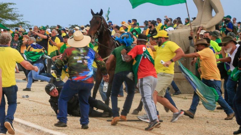 Un agente de la Policía Militar cae de su caballo durante los enfrentamientos con simpatizantes de Bolsonaro tras una invasión al Palacio Presidencial de Planalto.