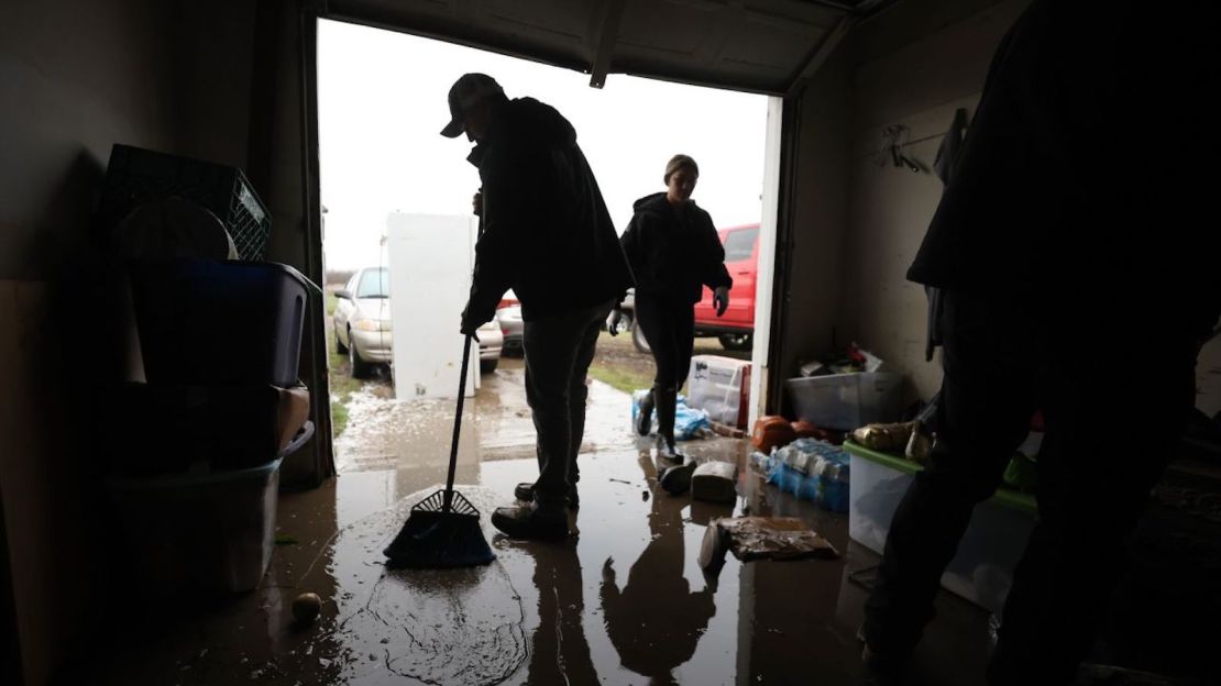 Randy Díaz barre el agua del garaje de la casa inundada en Planada, California, el 11 de enero de 2023.