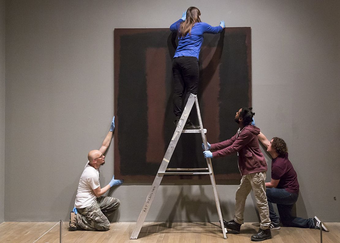 Especialistas en arte cuelgan la pintura del artista Mark Rothko "Negro sobre granate", de 1958 en el Tate Modern