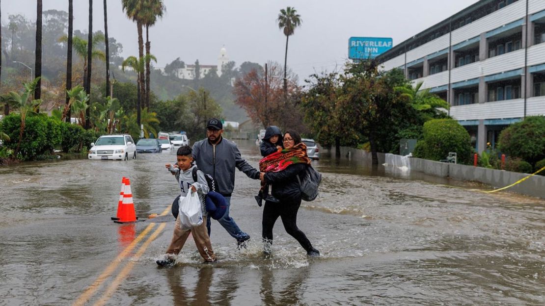 La gente camina en una calle inundada en San Diego, el 16 de enero de 2023.