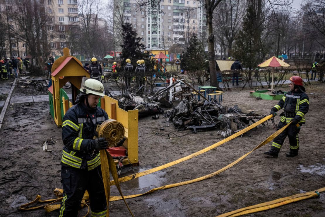 Bomberos frente a los escombros mientras los trabajadores de los servicios de emergencia trabajan en el lugar donde se estrelló un helicóptero el 18 de enero de 2023 en Brovary, Ucrania.