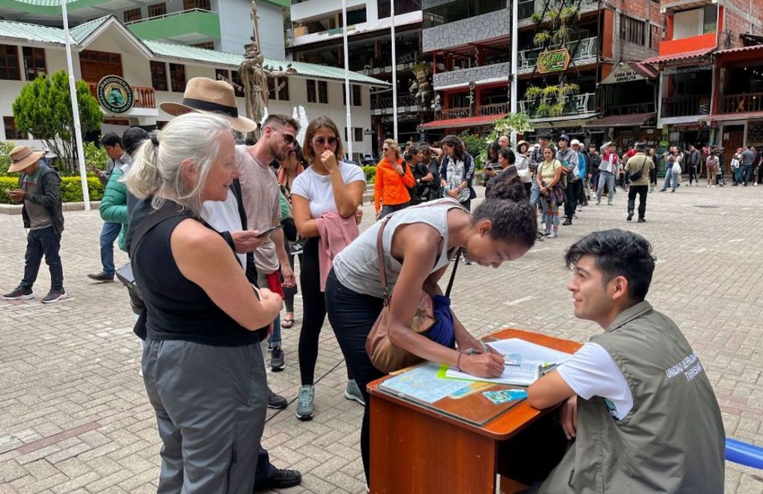 Turistas hacen fila para firmar una petición a la compañía ferroviaria para ser evacuados en un "tren humanitario" en Machu Picchu, Perú, el 20 de enero de 2023.