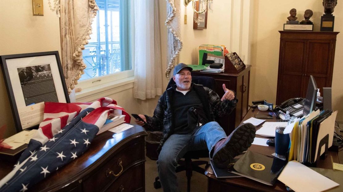 Richard Barnett, un partidario del entonces presidente Donald Trump, se sienta dentro de la oficina de la entonces presidenta de la Cámara de Representantes de Estados Unidos, Nancy Pelosi, mientras protesta dentro del Capitolio de Estados Unidos en la ciudad de Washington, 6 de enero de 2021.