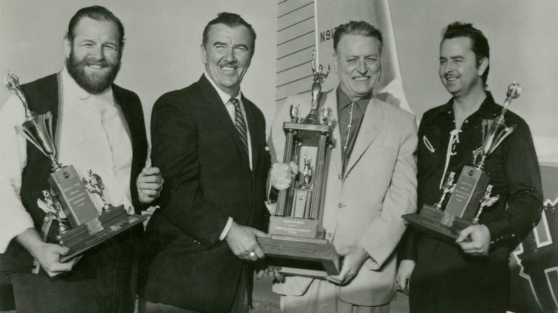 Robert Timm, Preston Foster (actor y jefe de operaciones en tierra), Warren "Doc" Bailey (propietario de Hacienda) y John Cook sostienen sus trofeos por el récord mundial de resistencia de vuelo. Crédito: Museo de Aviación Howard W. Cannon