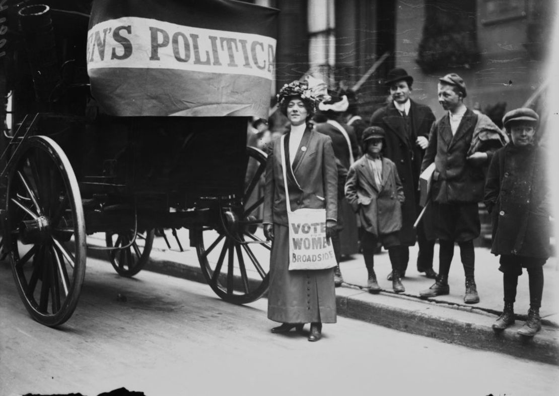 La Sra. Cook lleva copias de 'Votes for Women Broadside', una publicación emitida por la Unión Política de Mujeres en 1912. El uso del violeta para representar la lucha por los derechos de las mujeres está estrechamente vinculado a los movimientos sufragistas del Reino Unido y Estados Unidos.