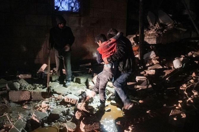 Un hombre lleva a un niño herido luego de un terremoto en la ciudad de Jandaris, en el campo de la ciudad de Afrin, en el noroeste de Siria, en la parte de la provincia de Alepo.