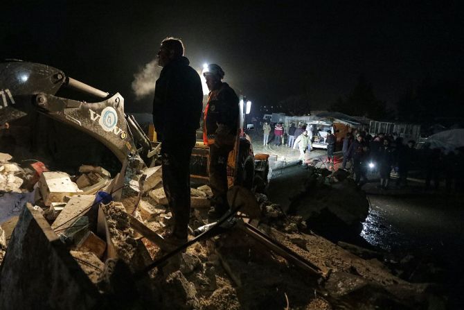 Rescatistas sirios (Cascos Blancos) y residentes se reúnen cerca de un edificio derrumbado tras un terremoto, en la ciudad fronteriza de Azaz, en el norte de la provincia de Alepo, controlada por los rebeldes.