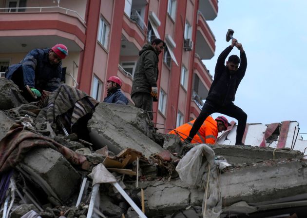 Varias personas buscan supervivientes en un edificio destruido en Adana, Turquía, el 6 de febrero.