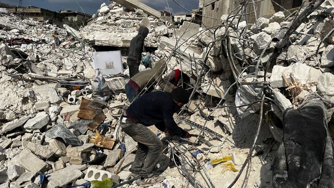 Residentes de un edificio destruido usando sus manos para quitar tierra y escombros en su búsqueda desesperada de sus seres queridos.