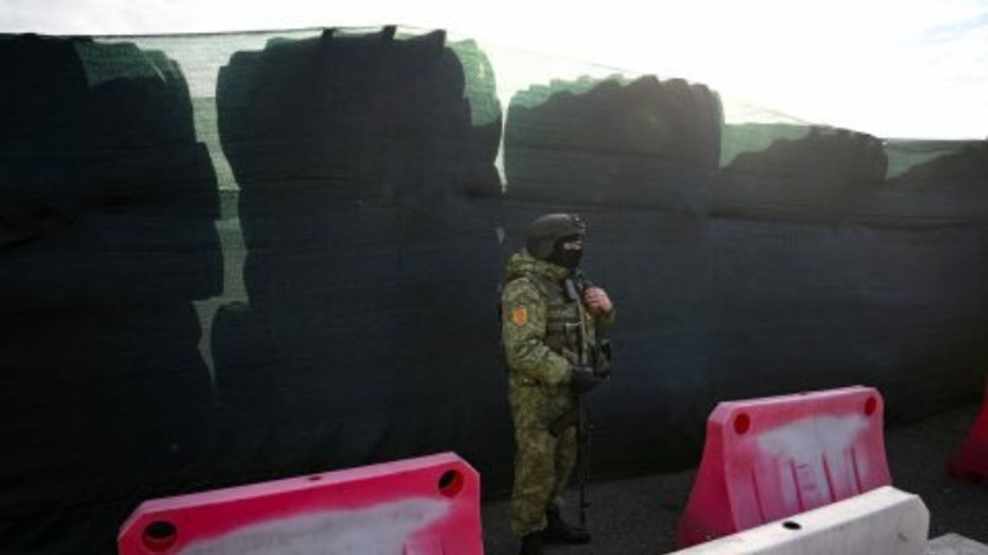 Un guardia fronterizo de Belarús vigila junto a una barricada hecha con neumáticos de camiones en el cruce fronterizo de Dyvin, entre Belarús y Ucrania, en la región de Brest el 15 de febrero de 2023.