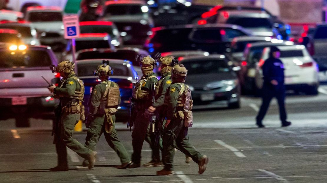 Agentes de la ley caminan en el estacionamiento del centro comercial después del tiroteo.