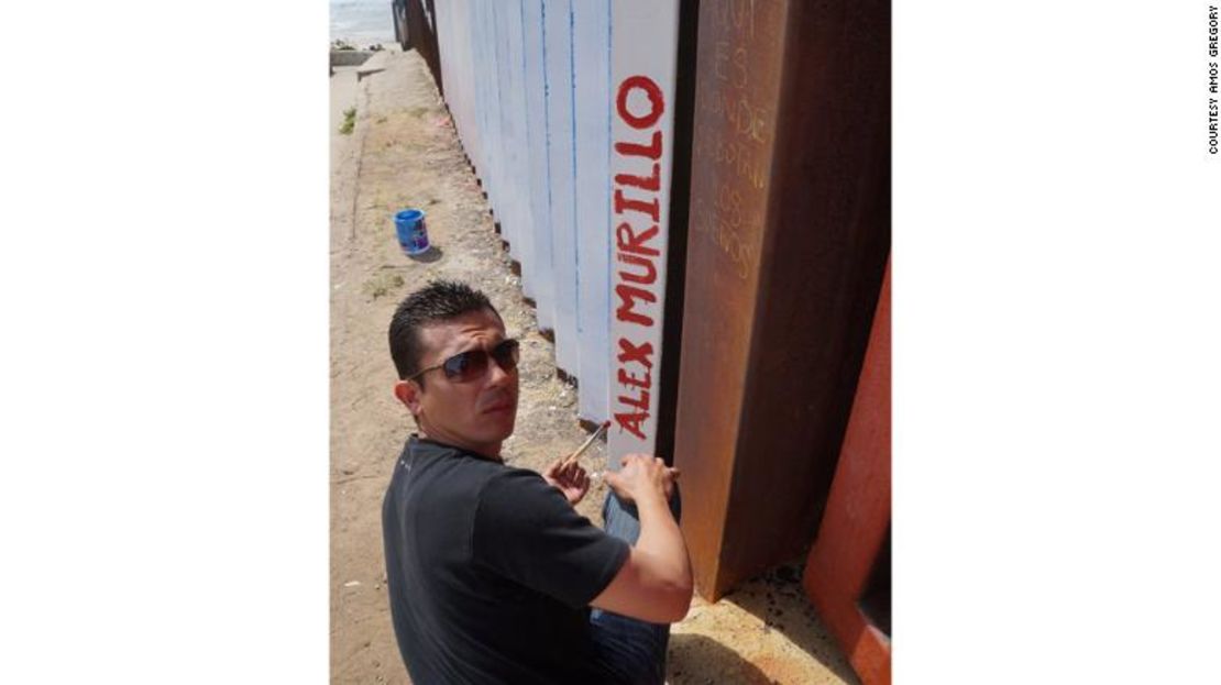 Alex Murillo, un veterano de la Armada deportado de Phoenix, pinta su nombre en el mural en Tijuana, México. Murillo fue deportado en 2012 tras una condena por drogas.