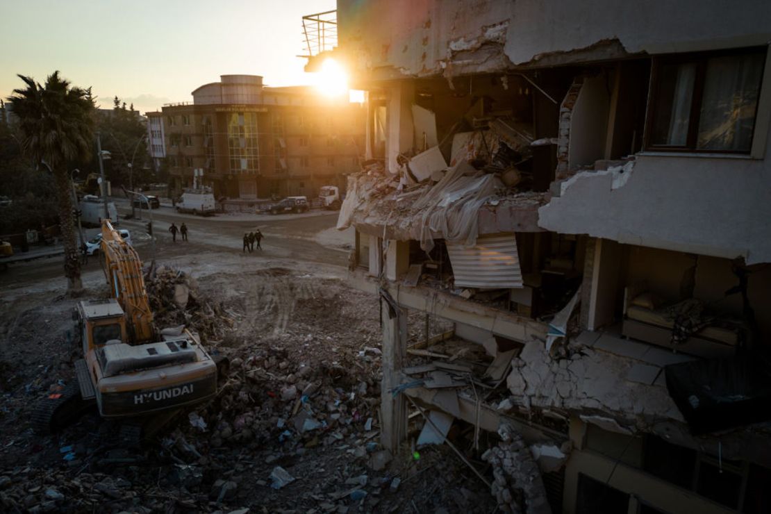 Hombres caminan por una calle en medio de escombros de edificios destruidos el 20 de febrero de 2023 en Hatay, Turquía.