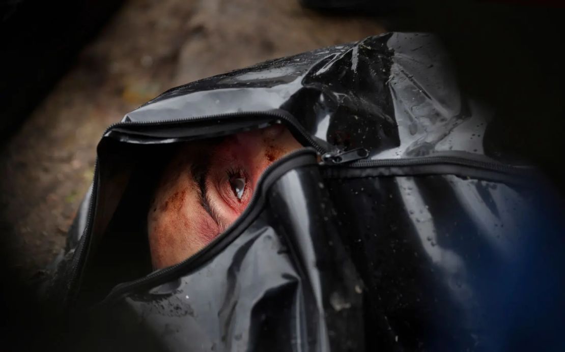 Los ojos de un hombre muerto, que está en una bolsa de cadáveres en Bucha, quedaron abiertos.