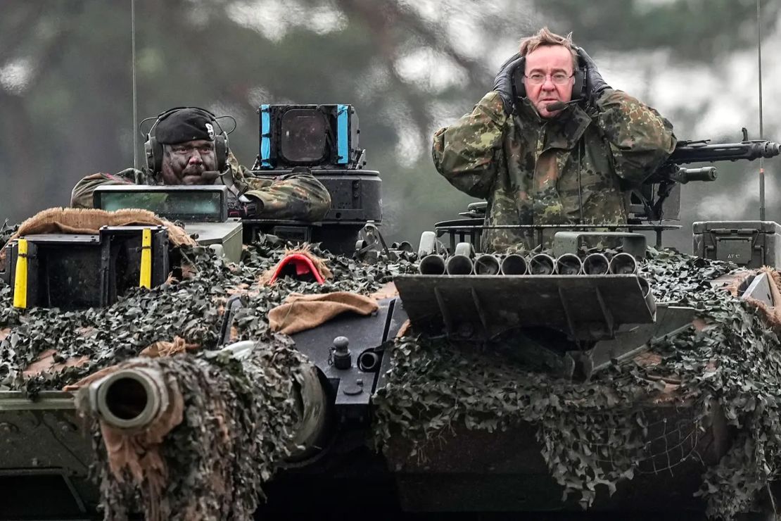 El ministro de Defensa alemán, Boris Pistorius, a la derecha, sentado en un tanque Leopard 2 en un cuartel de campaña en Alemania.