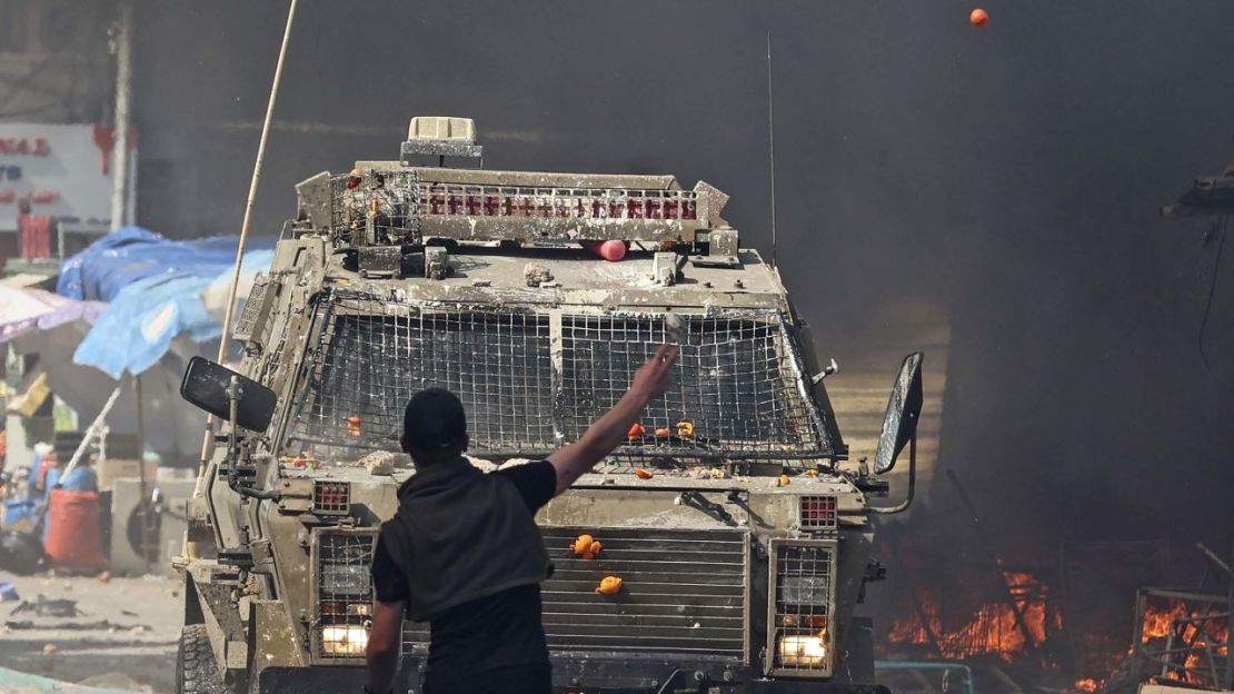 Un palestino se enfrenta a un vehículo militar israelí durante una redada en la ciudad de Naplusa, en Ribera Occidental, el 22 de febrero de 2023.