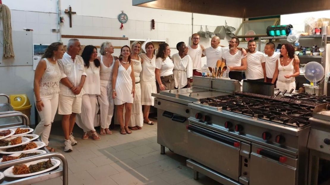 Los huéspedes posan para una foto con los reclusos que trabajan en el hotel de Pianosa. Crédito: Cortesía de Giulia Manca