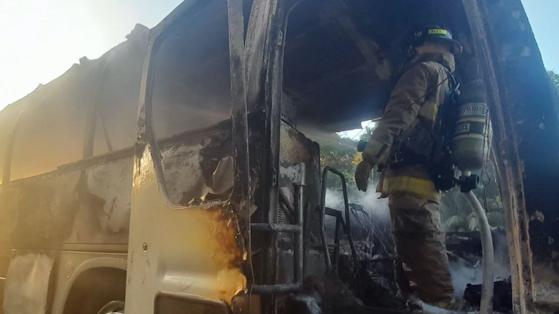 Bomberos apagando el incendio de un atobús de migrantes en Panamá.