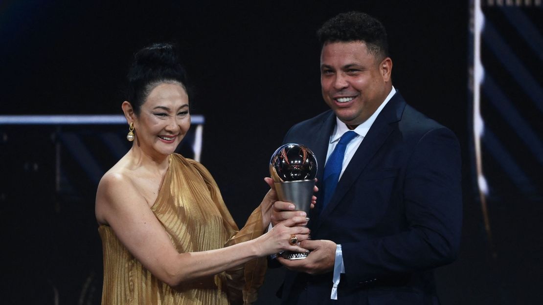 Marcia Aoki y Ronaldo sostienen el premio especial que la FIFA entregó en honor a Pelé.